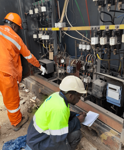 Two engineers taking measurements and notes at a site in Mozambique.